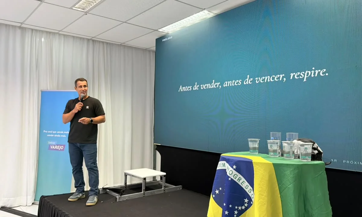 Bruno Fontes no palco com a frase Antes de vender, antes de vencer, respire, projetada no telão